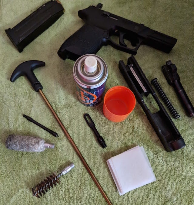 essential firearm cleaning supplies and field stripped weapon