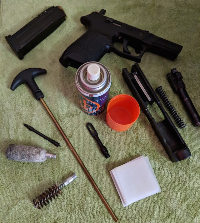 essential firearm cleaning supplies and field stripped weapon